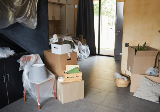 Intérieur de maison encombré de cartons et montrant un certain désordre, illustrant la question sur le coût du service de débarras lors d'un déménagement.